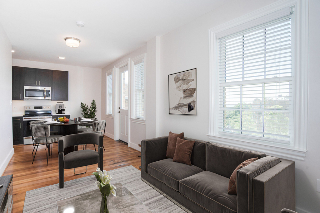 a living room with a couch and a chair and a kitchen with a dining room
