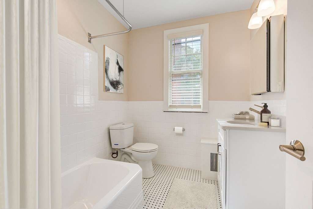 a bathroom with a toilet and a tub and a sink