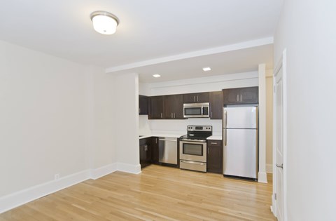 A kitchen with a white fridge and stove top oven.