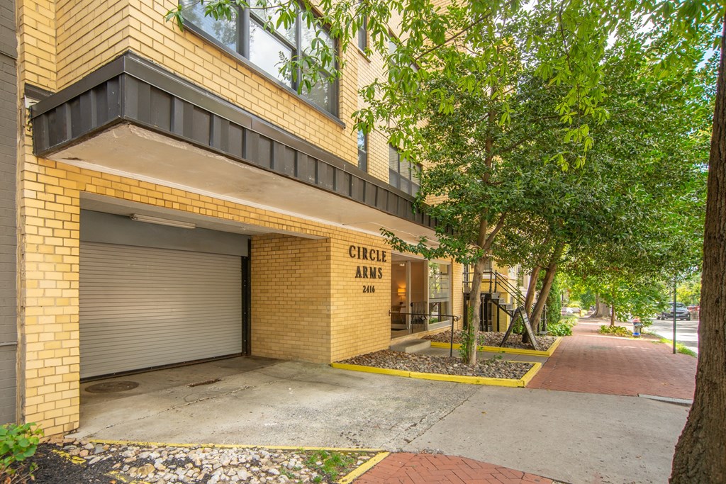 a building with a garage door and trees in front of it