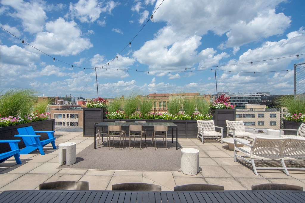 a rooftop patio with tables and chairs and a view of the city