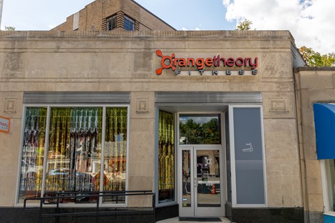 the front of a store with a sign on the side of a building