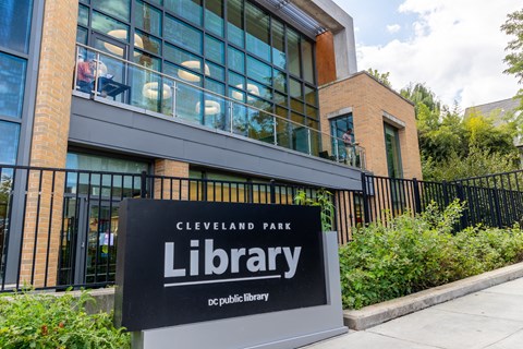 a sign in front of a building with a library