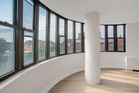 A white pillar in a room with large windows.