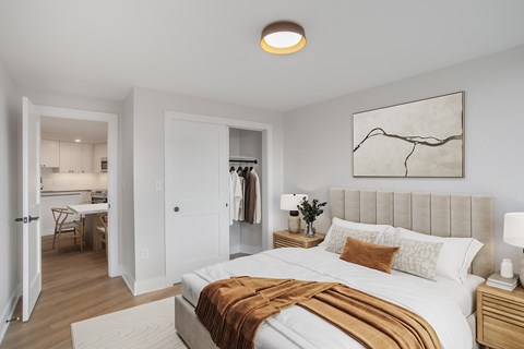 A bedroom with a large bed and a painting on the wall.