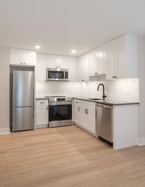 A modern kitchen with stainless steel appliances and white cabinets.