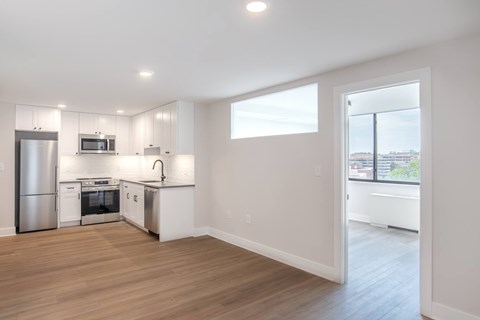 A kitchen with white cabinets and a stainless steel refrigerator.