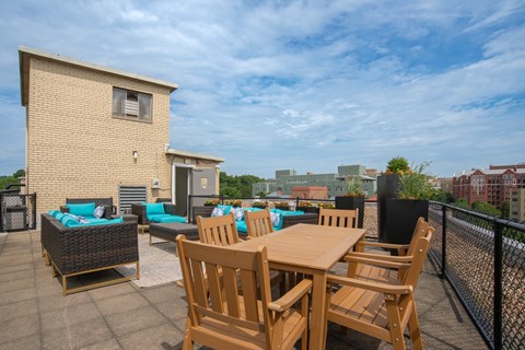 A patio with a table and chairs overlooks a cityscape.