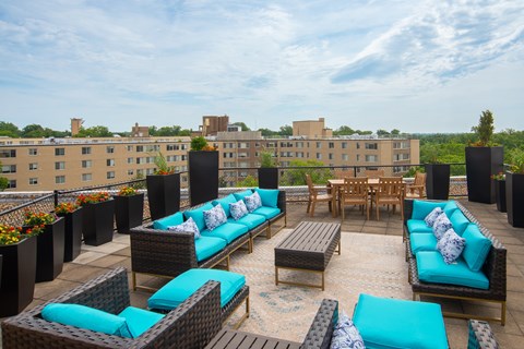 A patio with blue cushions and furniture.