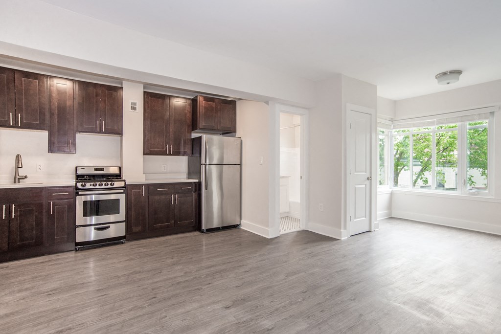an empty kitchen with wooden cabinets and stainless steel appliances