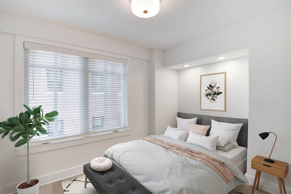 a bedroom with a bed and a large window