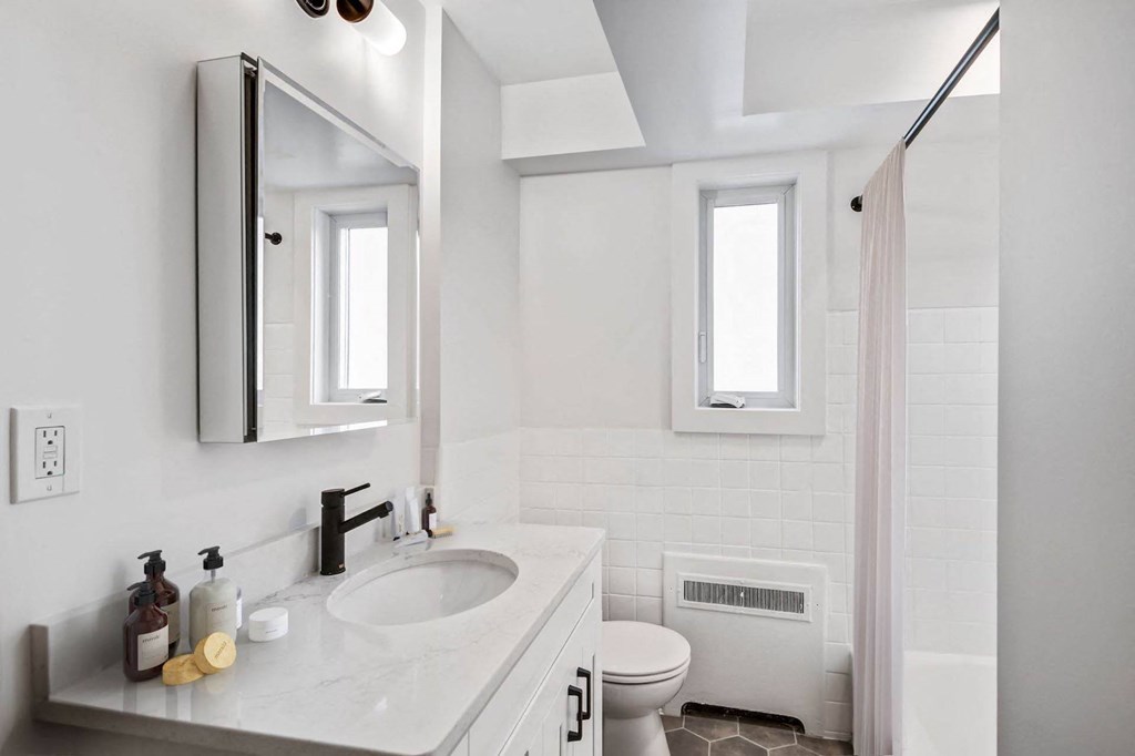 a white bathroom with a sink and a toilet