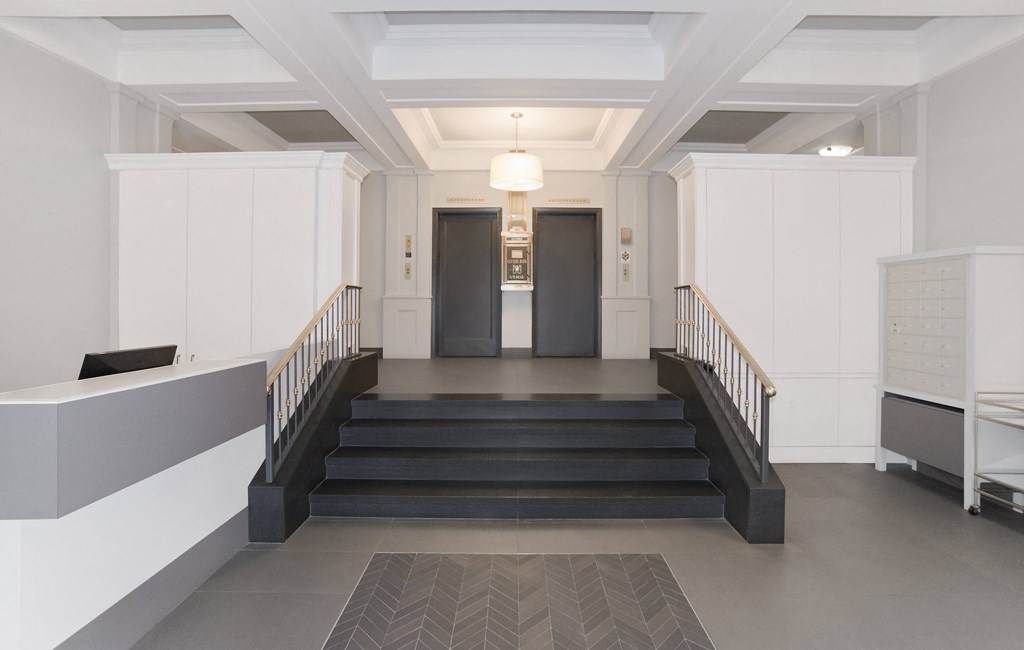 a view of a large hall with stairs and two doors