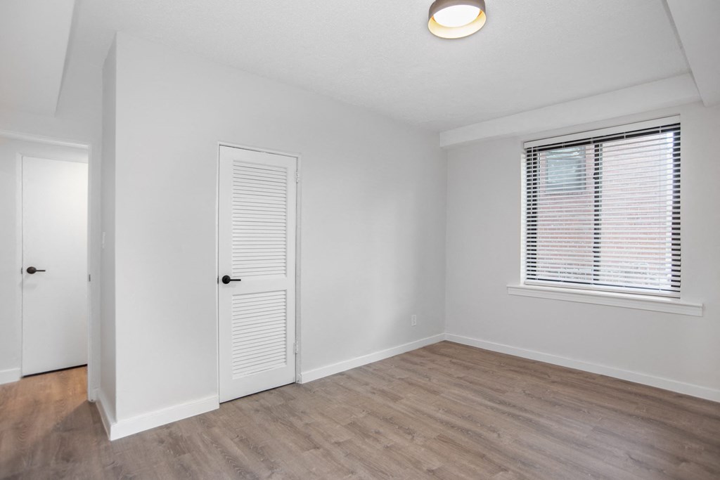 the living room of an empty home with white walls and wood floors