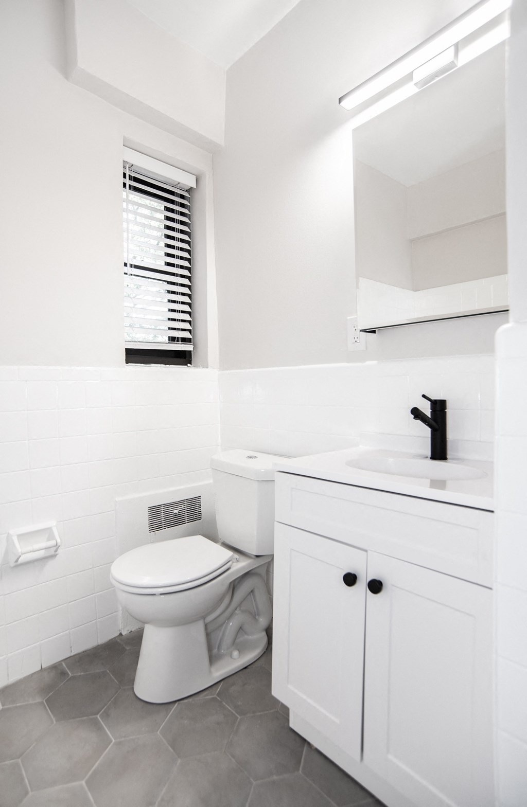 a white bathroom with a toilet and a sink