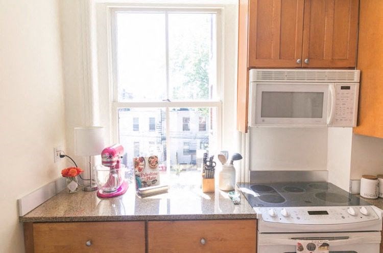 a kitchen with a stove and a microwave and a window
