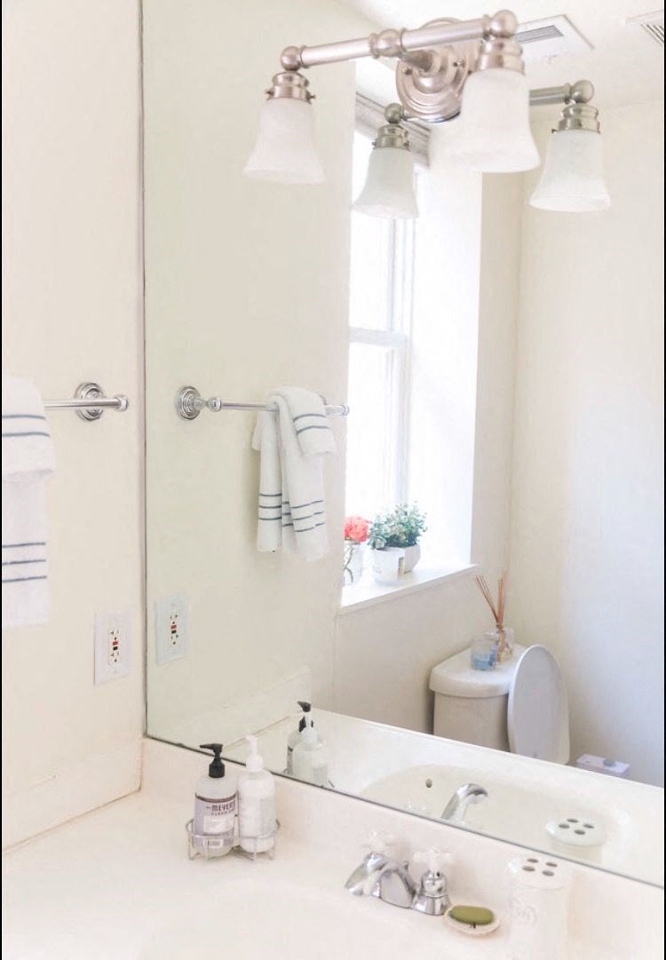 a bathroom with a mirror and a sink and a toilet