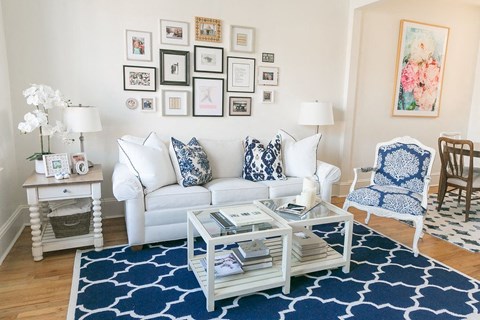 a living room with a white couch and a blue rug