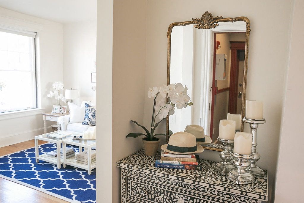 a living room with a mirror and a blue rug