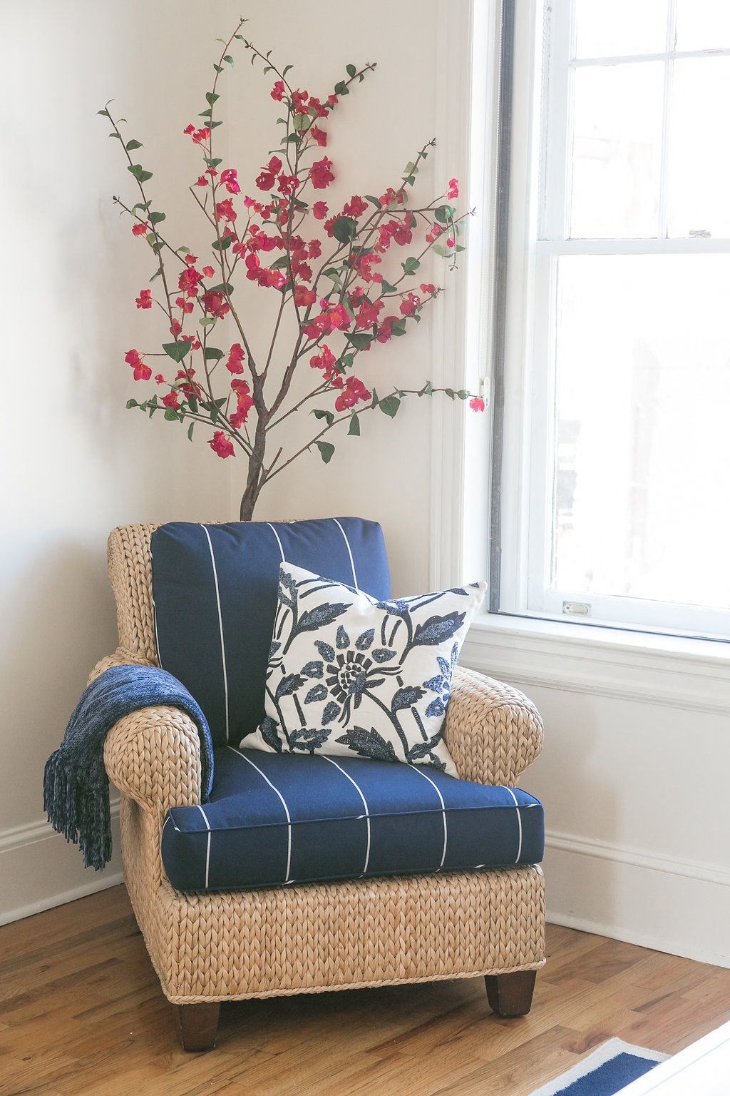 a blue and white chair with a tree in the corner