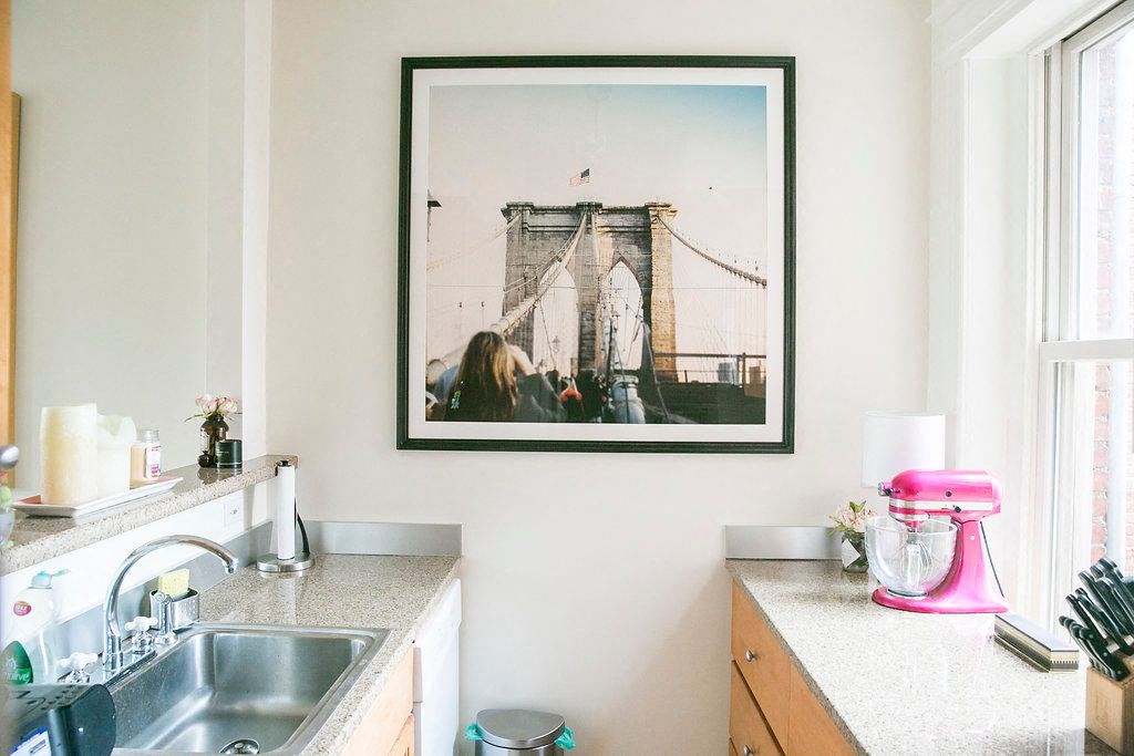 a kitchen with a picture of a bridge on the wall
