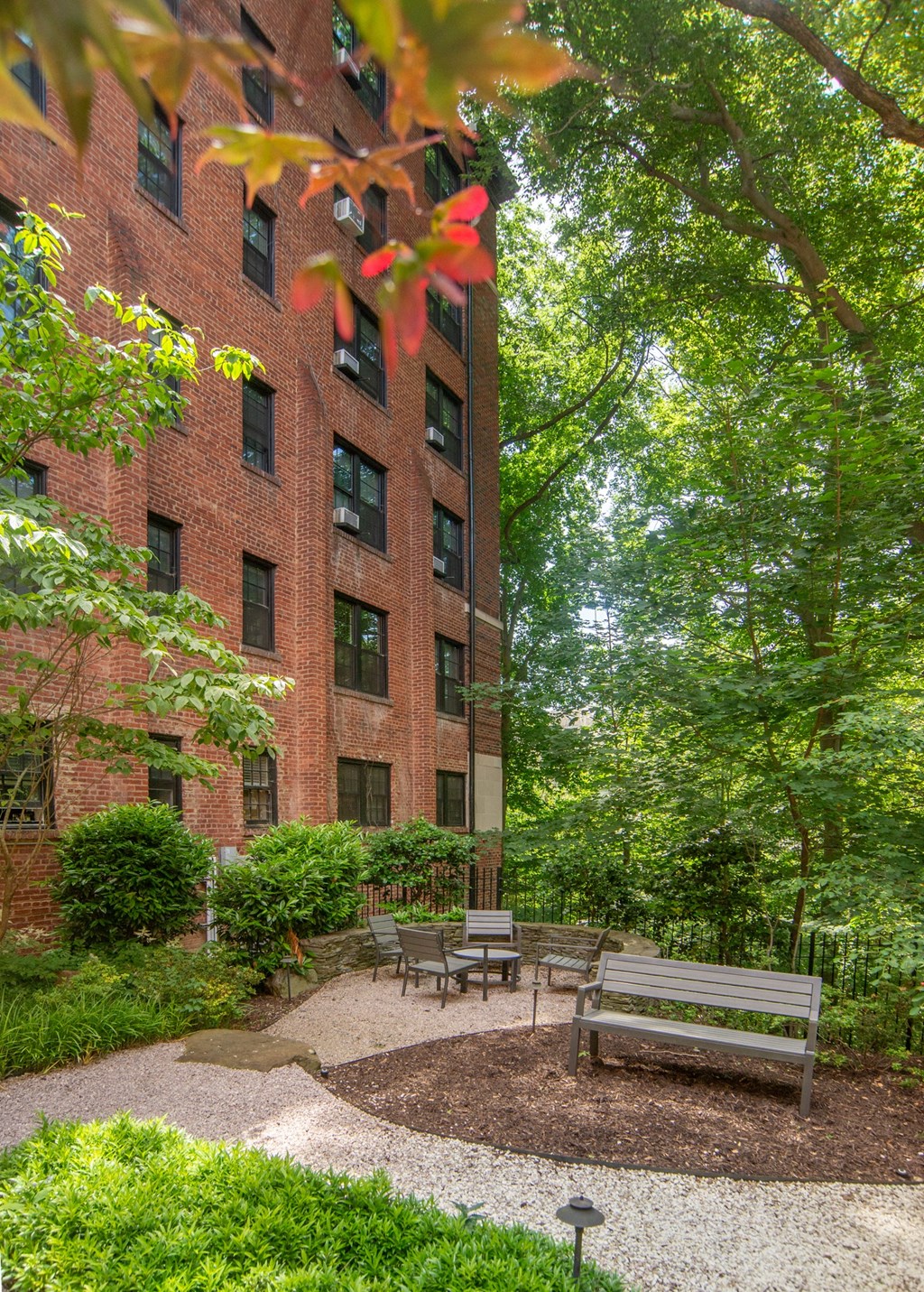 a courtyard with benches and a brick building