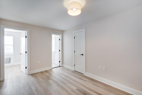 a living room and dining room with white walls and wood floors