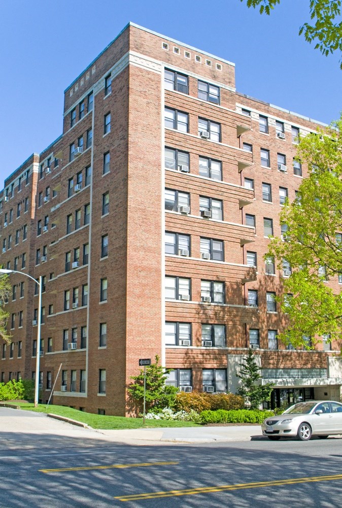 a tall brick building with a car parked in front of it