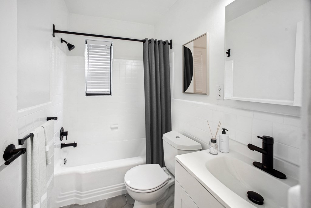 a bathroom with a white sink and toilet next to a bathtub with a shower curtain