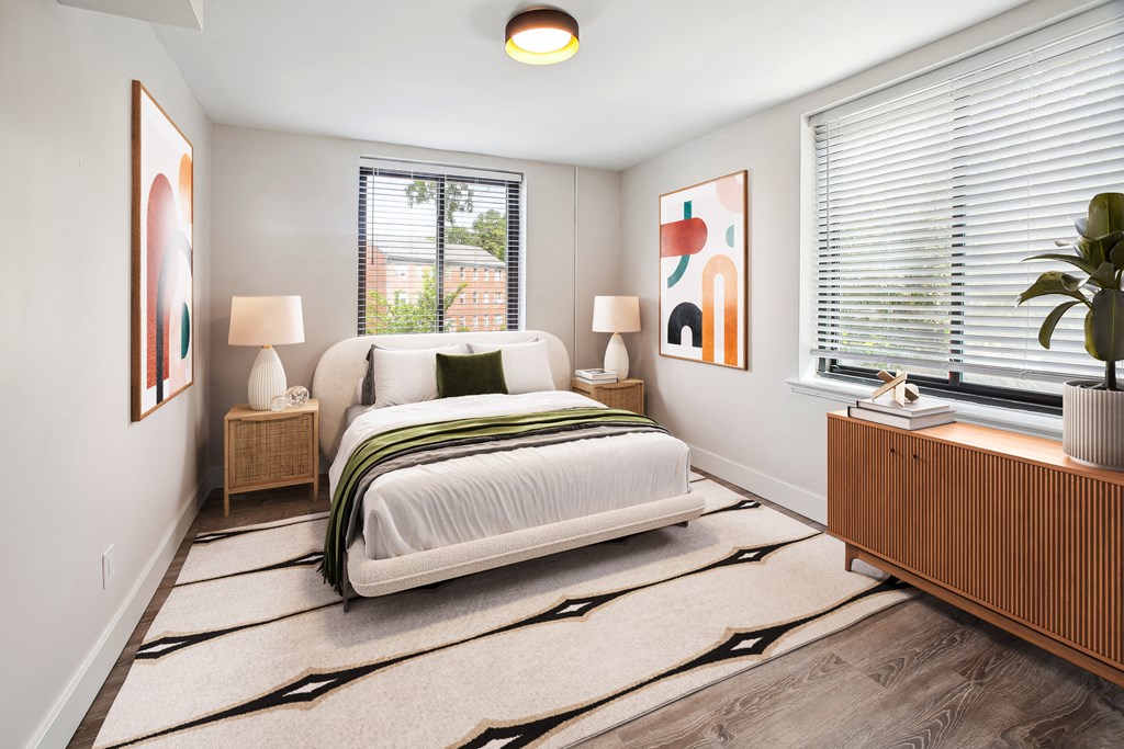 a bedroom with a bed and two windows