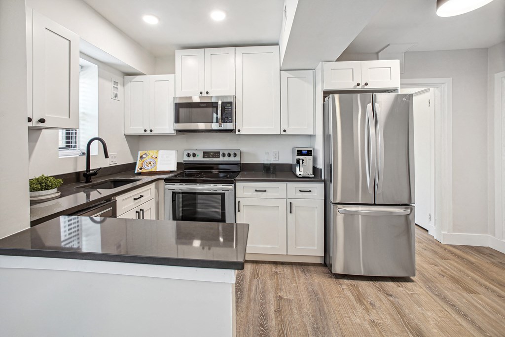 a kitchen with white cabinets and stainless steel appliances