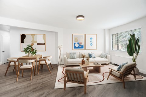 A living room with a white couch, wooden chairs, and a rug.