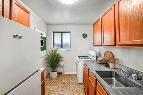 A small kitchen with a white fridge and a window.
