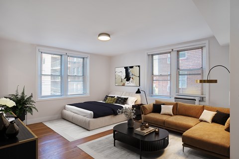 A bedroom with a bed, a couch, and a coffee table.