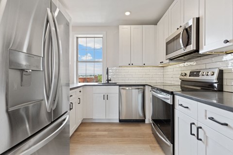 a kitchen with stainless steel appliances and white cabinets