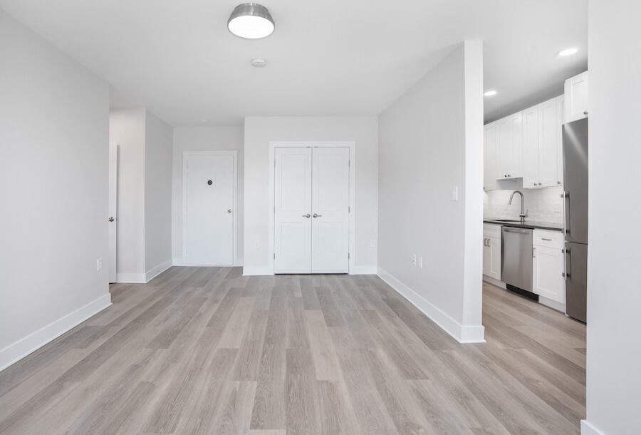 empty living room with a kitchen in the background