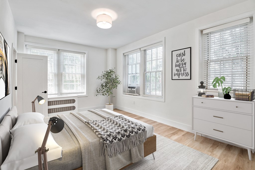 a bedroom with a bed and two windows