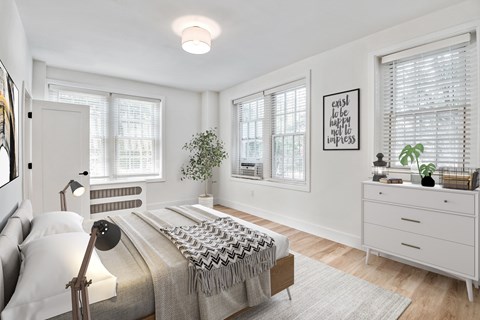 a bedroom with a bed and two windows