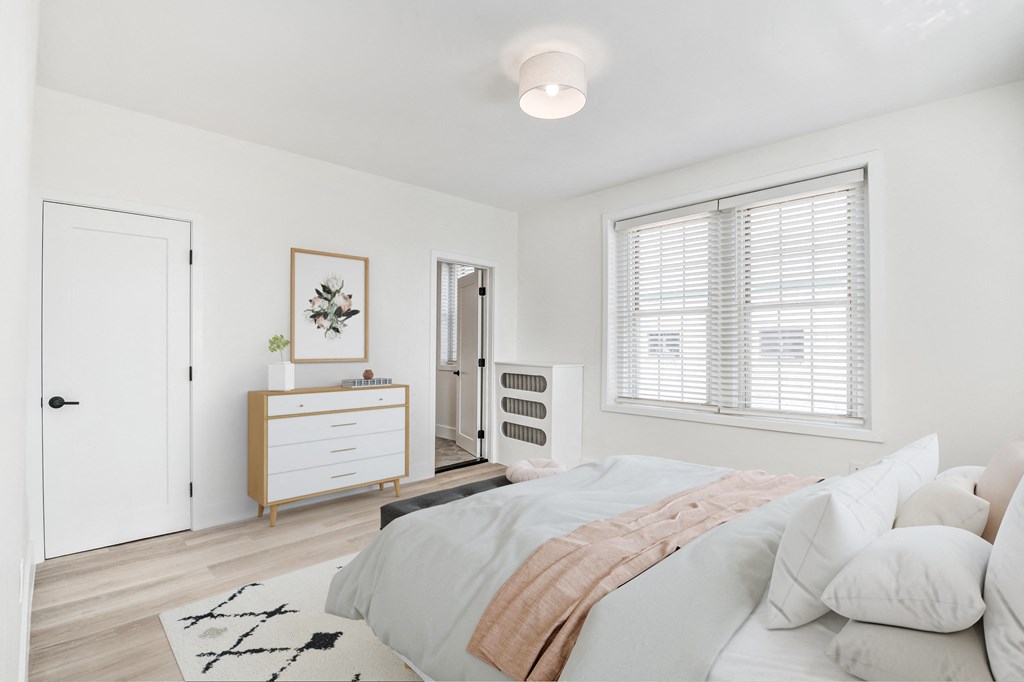 a bedroom with a bed and a dresser and a window