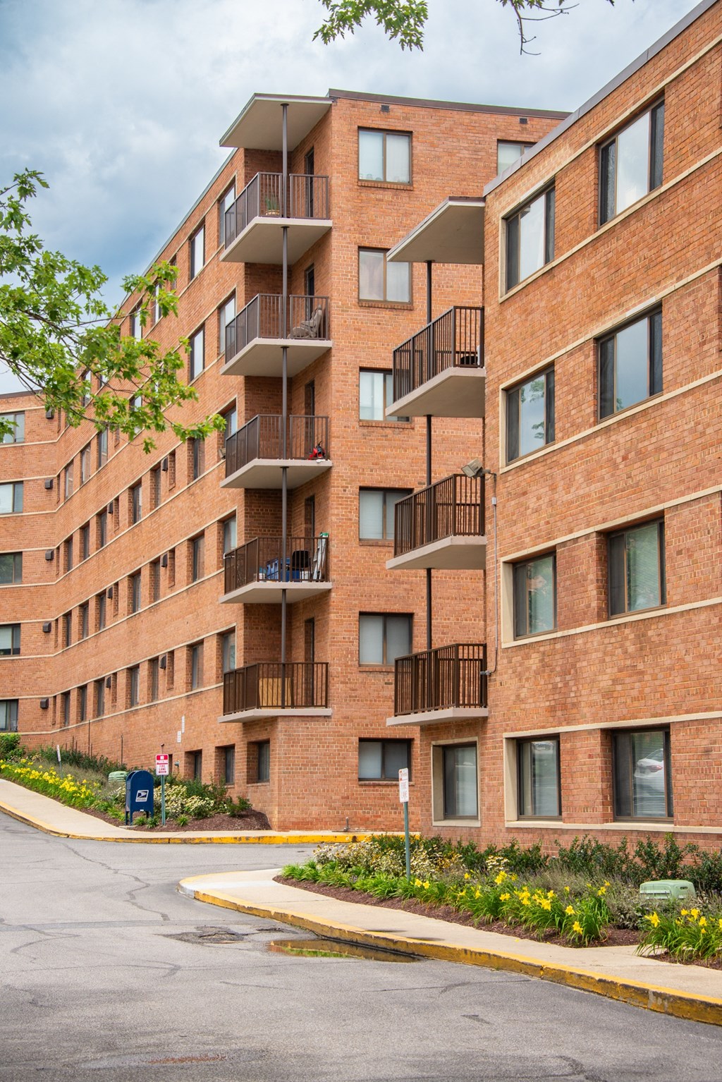 a large brick building with many balconies and a street in front
