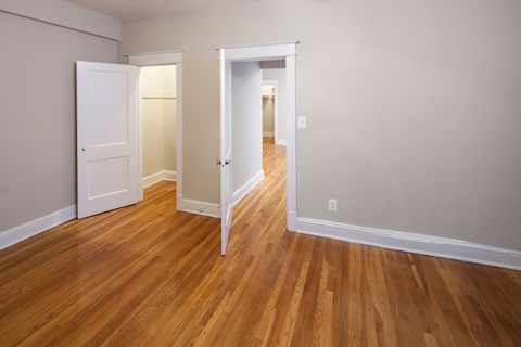 a living room and hallway with wood floors and white walls