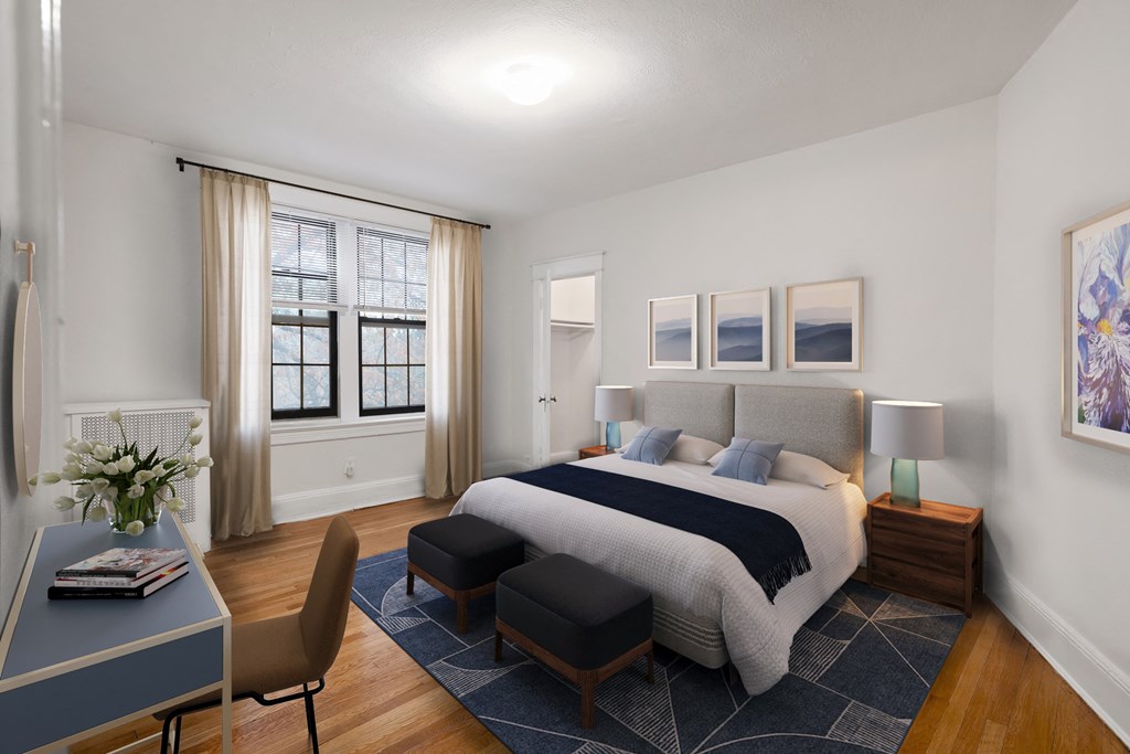 a bedroom with a bed and a desk and a window