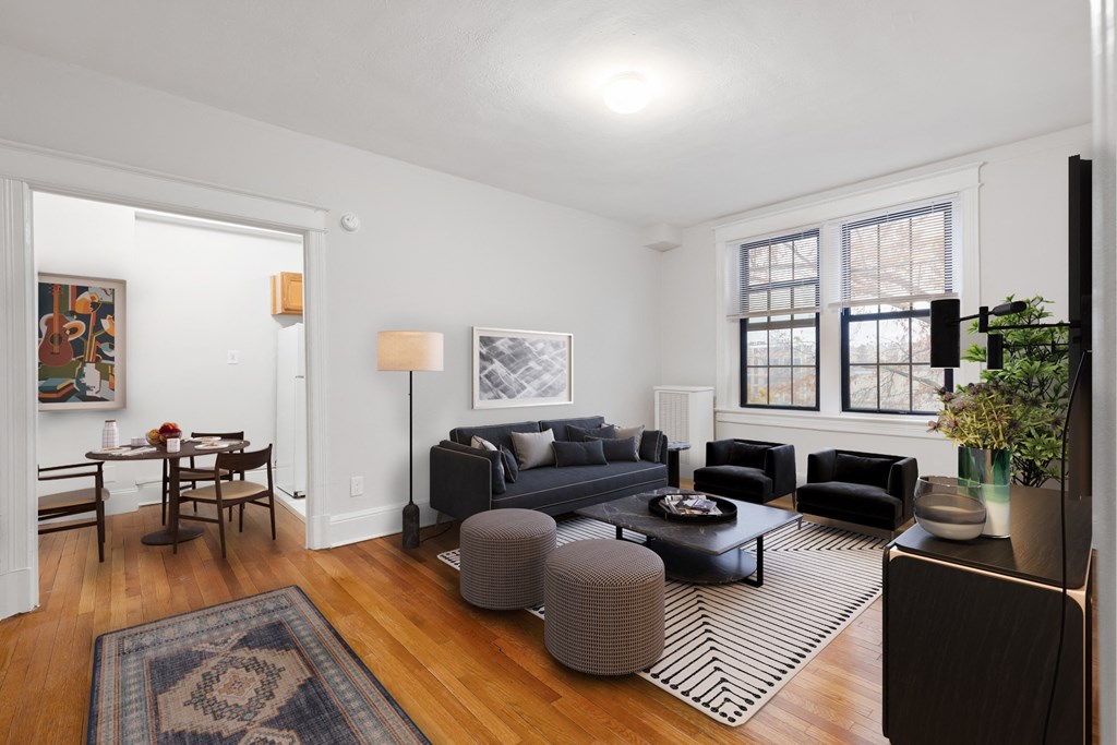a living room with two couches and a rug and a dining room table