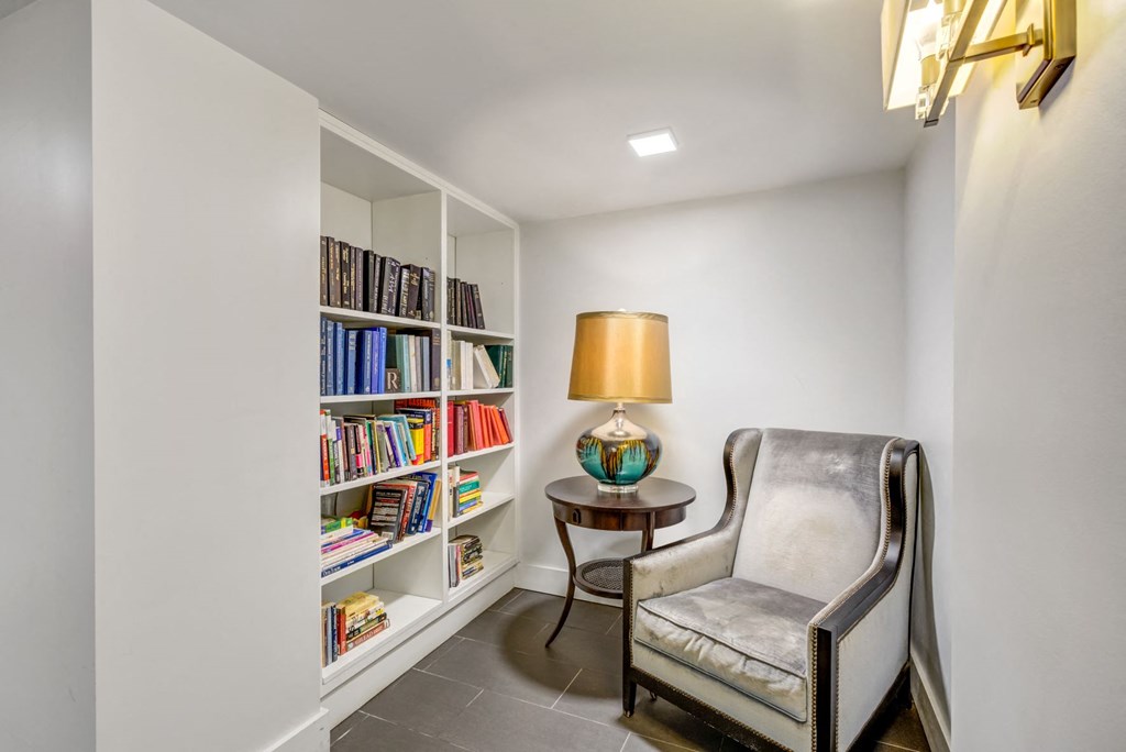 a library with a chair and a bookshelf full of books