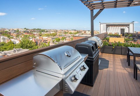 two bbqs on a roof deck with a view of the city