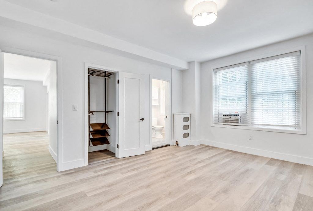 an empty living room with white walls and wood floors