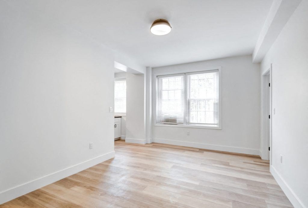 an empty living room with white walls and wood floors