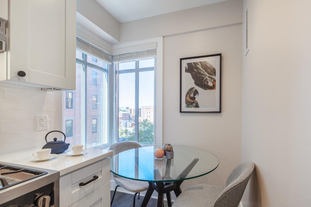 a kitchen and dining room with a large window and a table and chairs