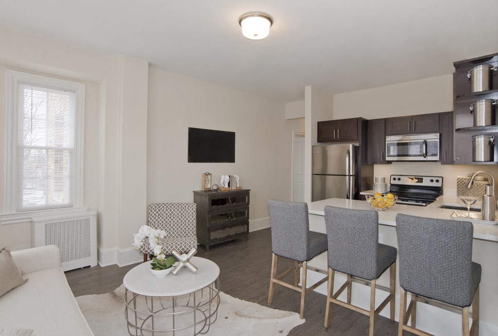 a living room with a kitchen and a table with chairs