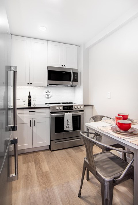 a kitchen with stainless steel appliances and a table and chairs